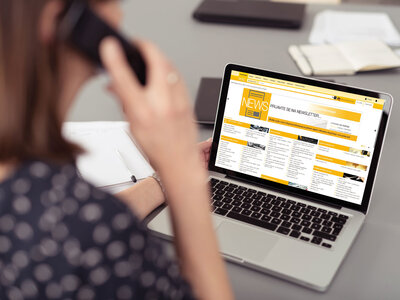 frau im bro schaut auf laptop und telefoniert